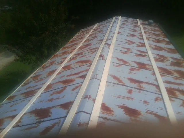 Rusted metal roof panels with new wood purlins before replacement — Storm Damage Roof Repair in Barksdale by Roofing Brothers