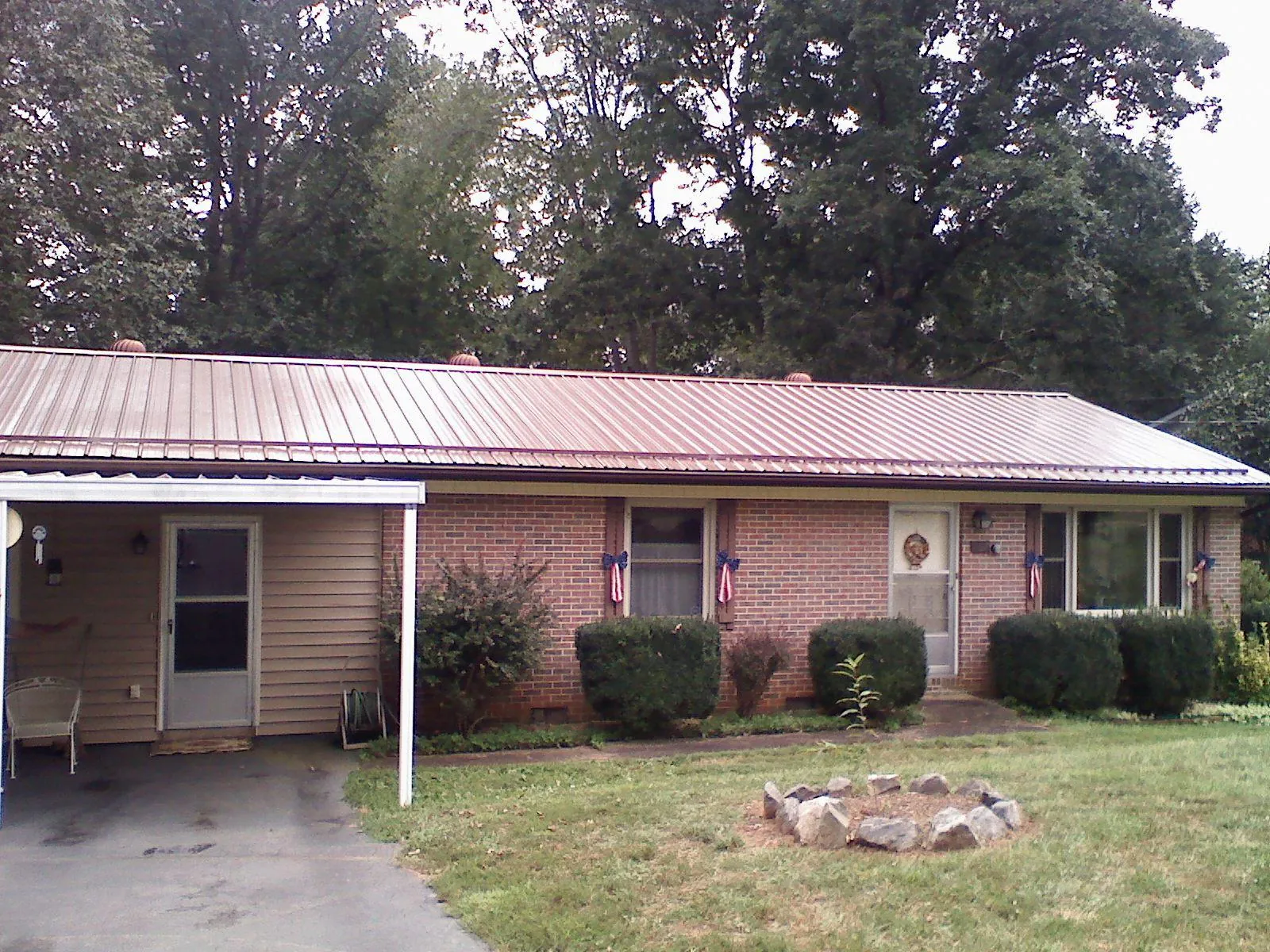 Bronze metal roof and carport on a brick ranch home — Roof Repair work by our crew in Barksdale